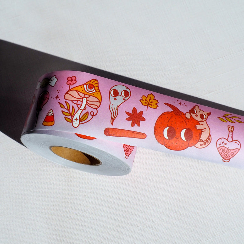 a roll of purple Halloween water activated packing tape with fall elements like mushrooms, potions and pumpkins,